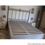 panoramica del letto con testata in ferro battuto.